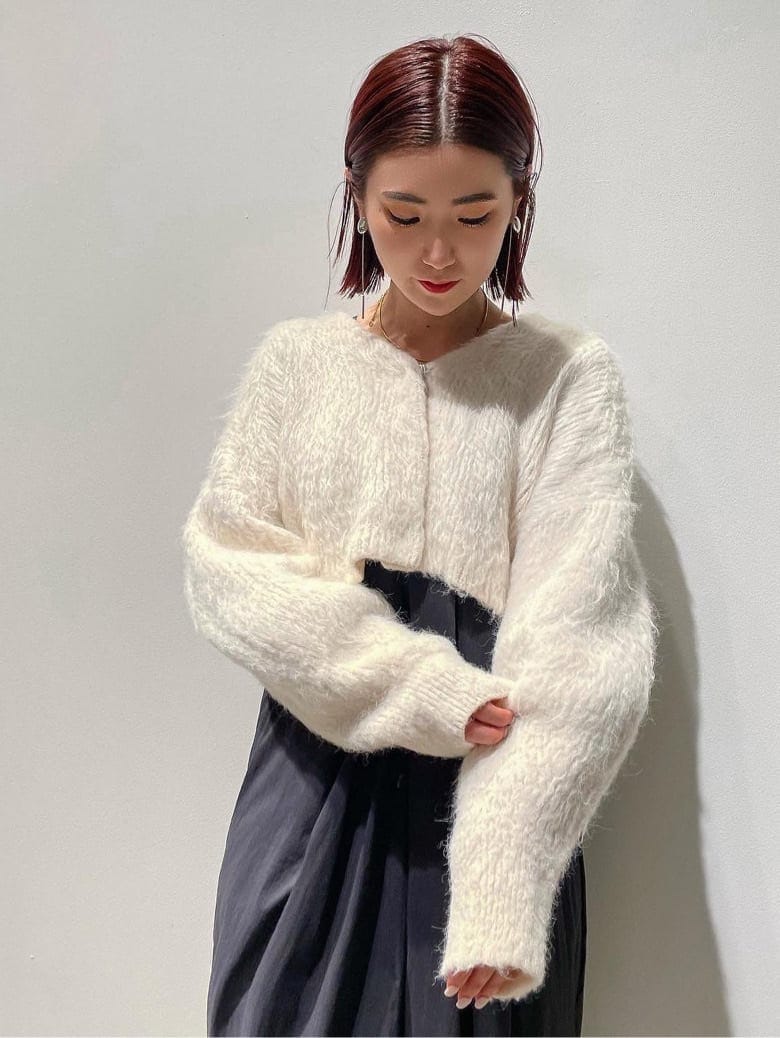 ブラック系のダウンジャケット/コート、ブラウン系のブーツ、ホワイト系のワンピースを着用したレディースの秋コーディネートの3枚目の写真