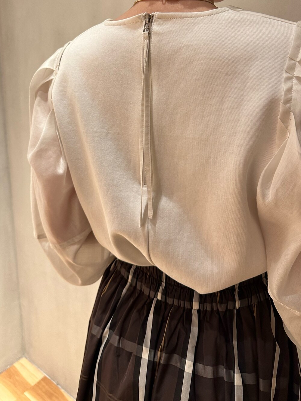 ホワイト系のTシャツ/カットソー、ブラウン系のスカート、ブラック系のパンプスを着用したレディースの春コーディネートの6枚目の写真