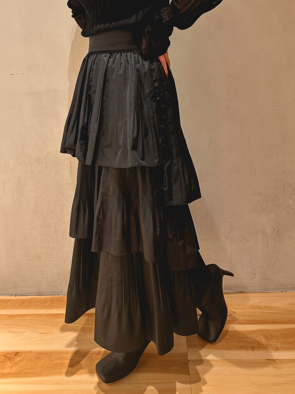 ブラック系のスカート、ブラック系のニット/セーター、グレー系のテーラードジャケットを着用したレディースの秋コーディネートの5枚目の写真