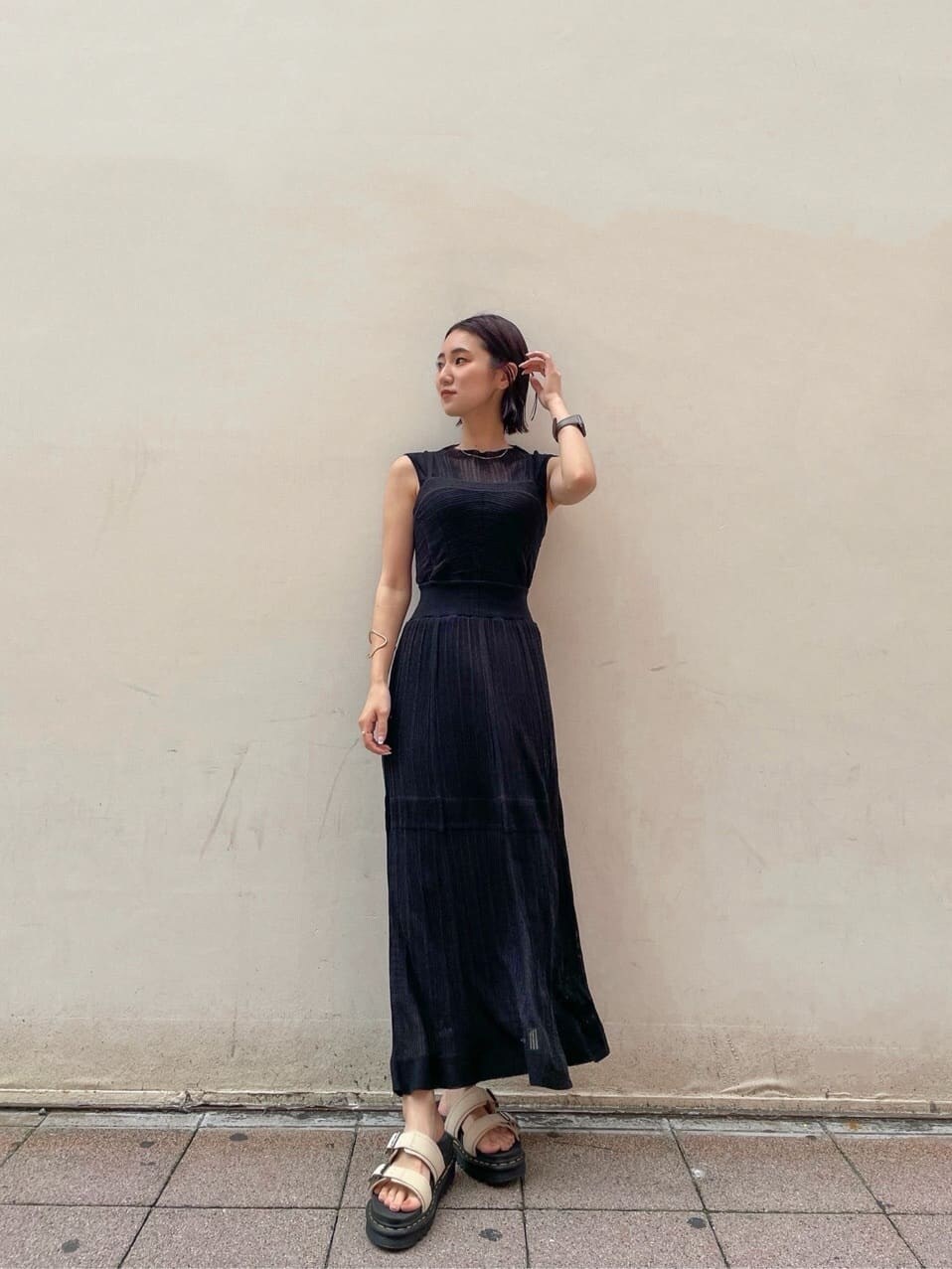 ベージュ系のサンダル、ブラック系のワンピース、ゴールド系のブレスレットを着用したレディースの夏コーディネートの2枚目の写真