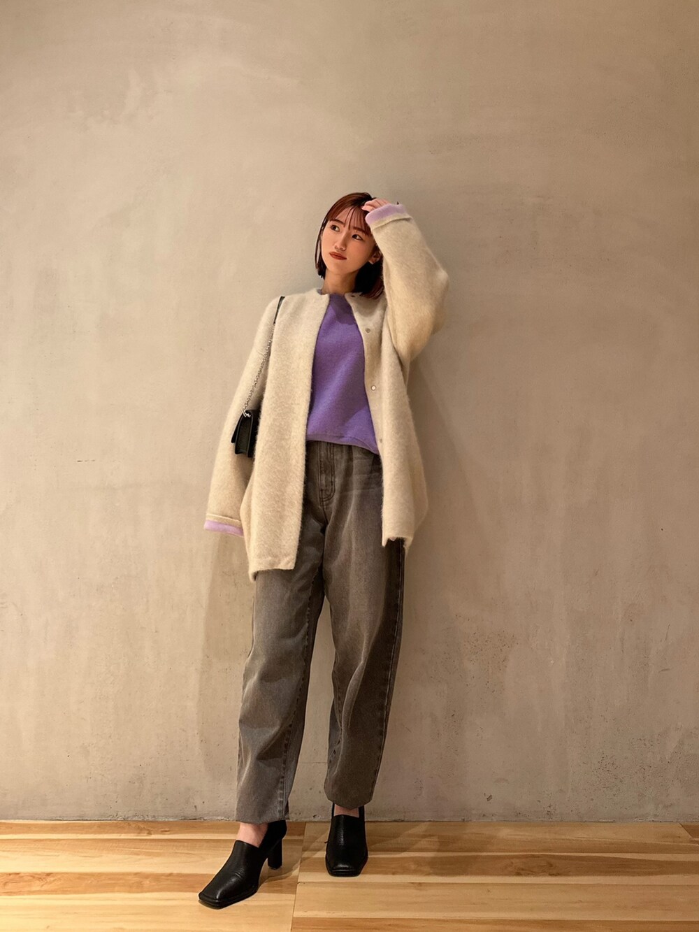 パープル系のニット/セーター、グレー系のデニムパンツ、ブラック系のパンプスを着用したレディースの夏コーディネートの6枚目の写真