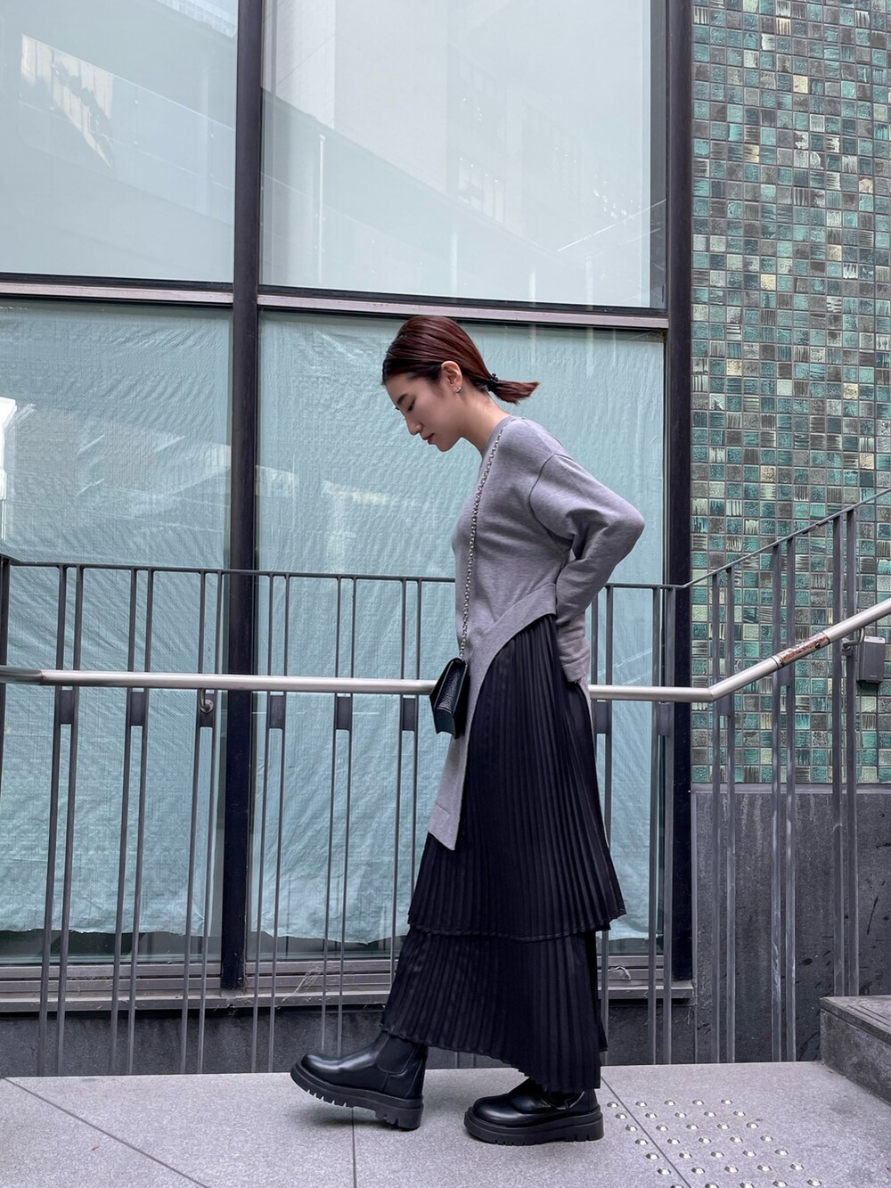 グレー系のワンピース、ブラック系のダウンジャケット/コート、ブラック系の財布を着用したレディースの冬コーディネートの6枚目の写真