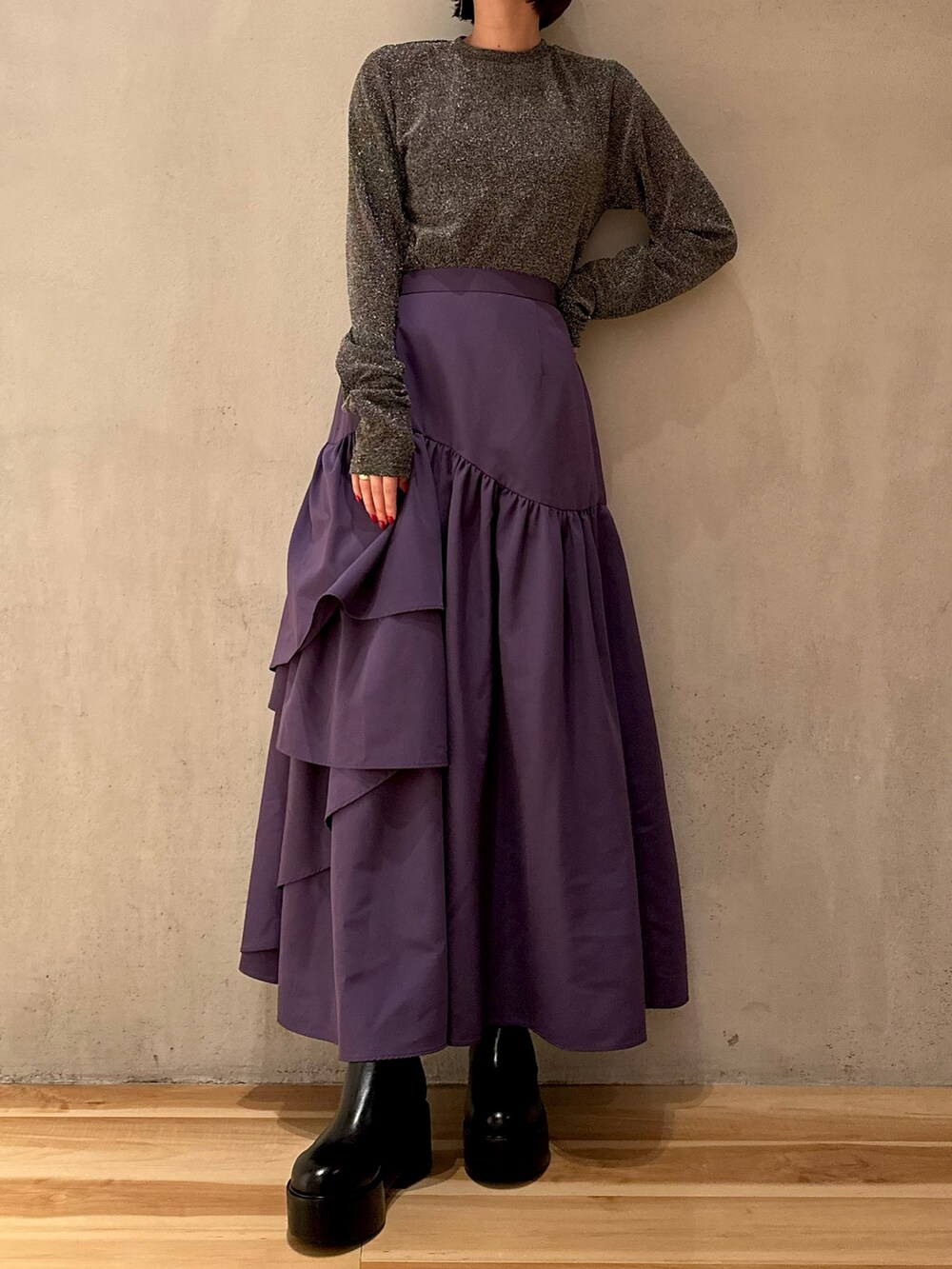 パープル系のスカート、ブラック系のノーカラーコート、シルバー系のTシャツ/カットソーを着用したレディースの秋コーディネートの5枚目の写真