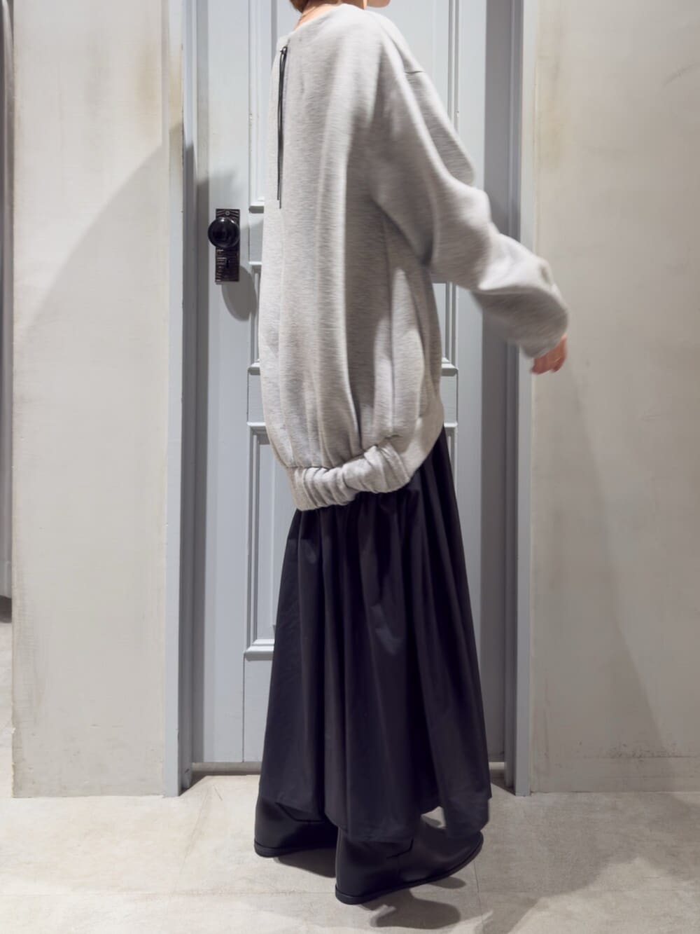 ブラック系のブーツ、グレー系のワンピースを着用したレディースの秋コーディネートの2枚目の写真