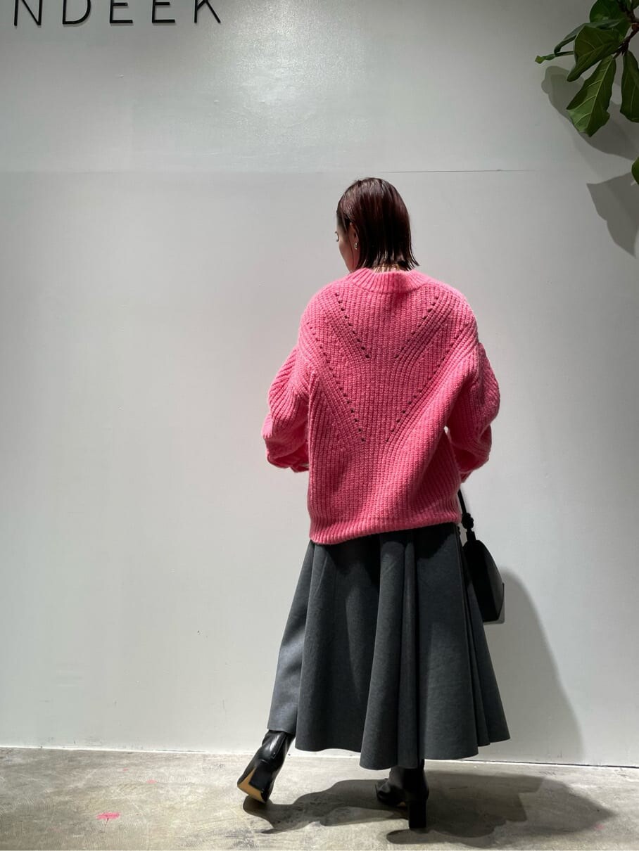 ピンク系のニット/セーター、グレー系のスカート、ブラック系のブーツを着用したレディースの秋コーディネートの7枚目の写真