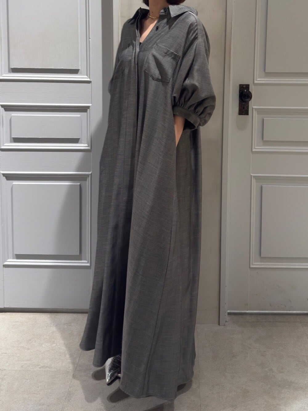 ブラック系のパンプス、グレー系のワンピースを着用したレディースの春コーディネートの7枚目の写真