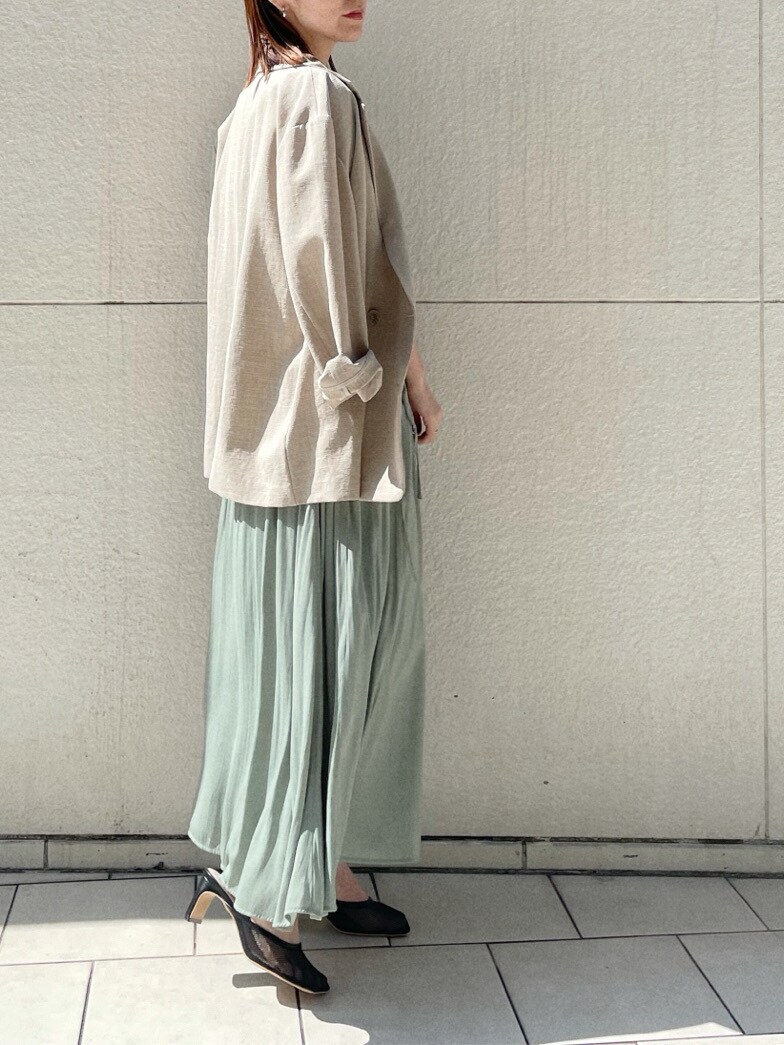 ブラック系のサンダル、ベージュ系のテーラードジャケット、グリーン系のワンピースを着用したレディースの春コーディネートの6枚目の写真