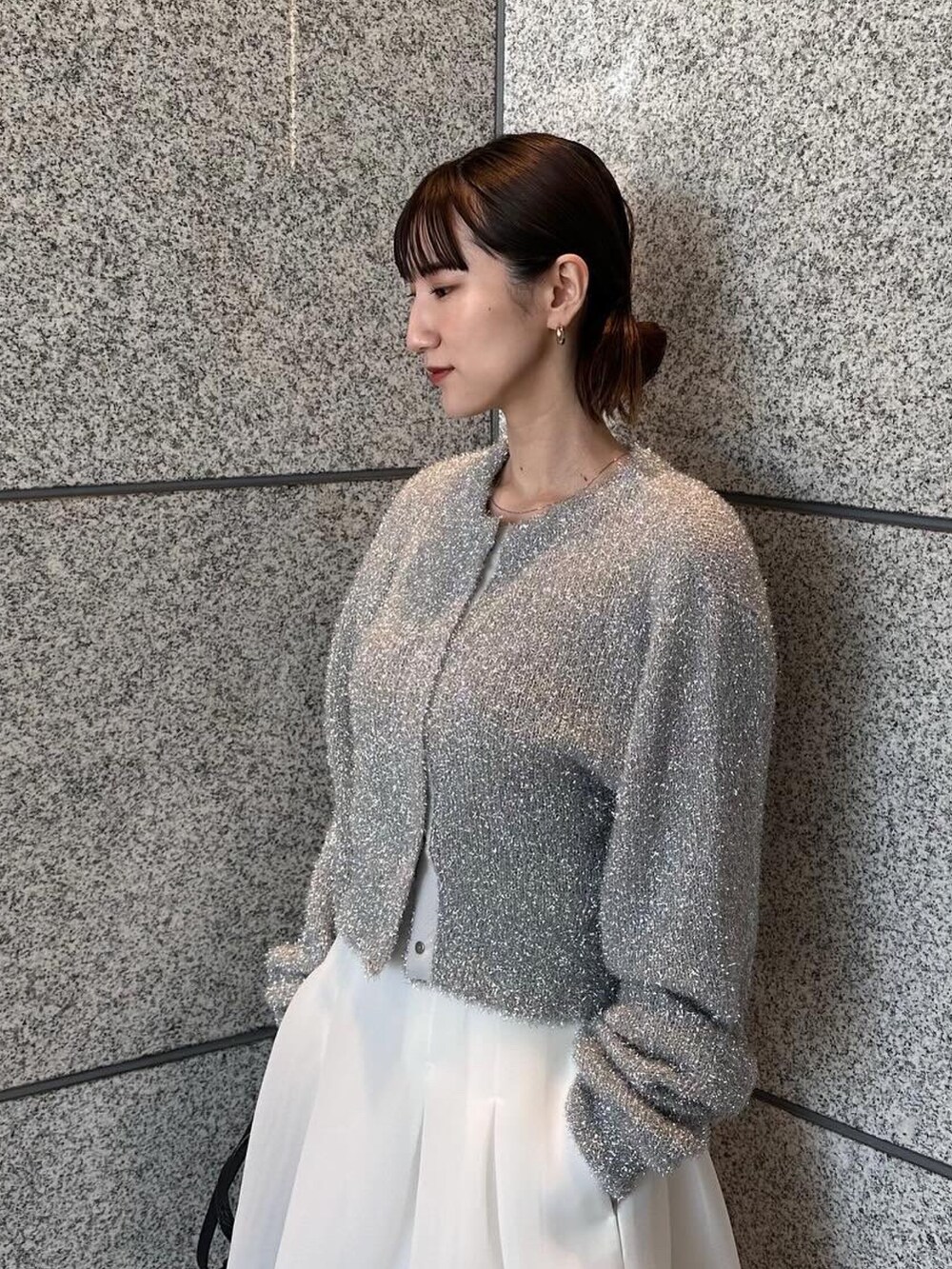 シルバー系のカーディガン/ボレロ、ホワイト系のスカート、ブラック系のサンダルを着用したレディースの冬コーディネートの3枚目の写真