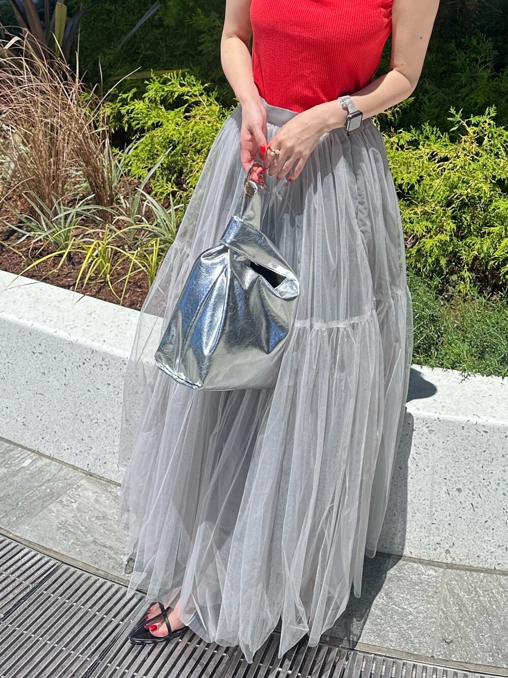 レッド系のタンクトップ、グレー系のスカートを着用したレディースの夏コーディネートの5枚目の写真