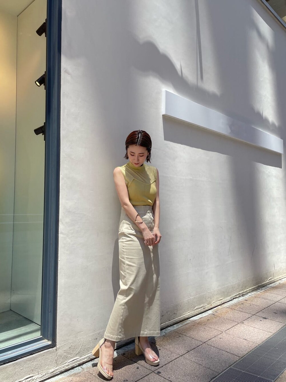 その他のパンプス、イエロー系のニット/セーター、ベージュ系のスカートを着用したレディースの夏コーディネートの3枚目の写真