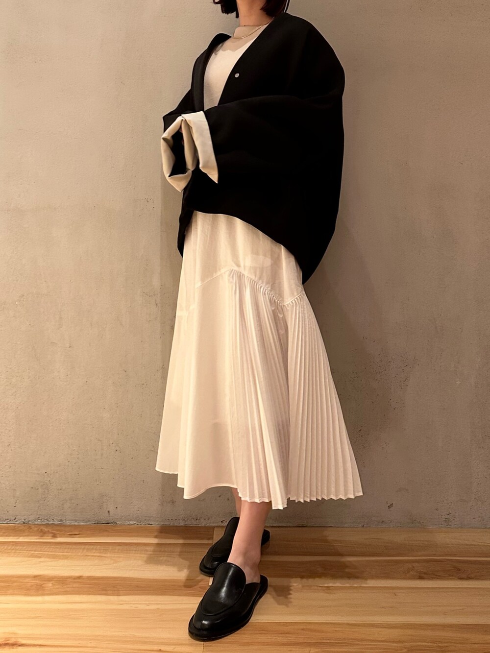 ホワイト系のワンピース、ブラック系のノーカラーコートを着用したレディースの春コーディネートの5枚目の写真