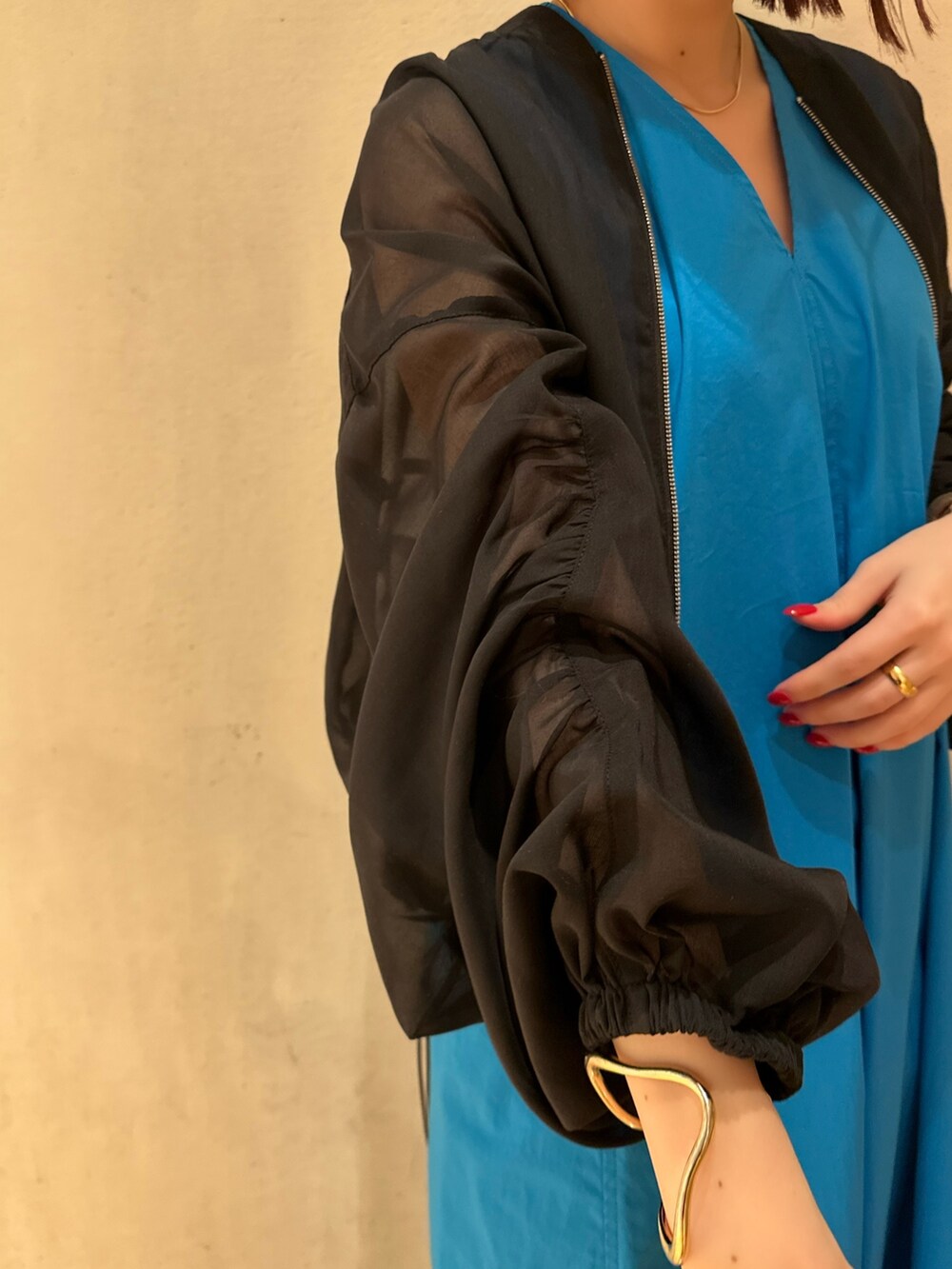 ブルー系のワンピース、ホワイト系のサンダル、ブラック系のブルゾンを着用したレディースの冬コーディネートの6枚目の写真