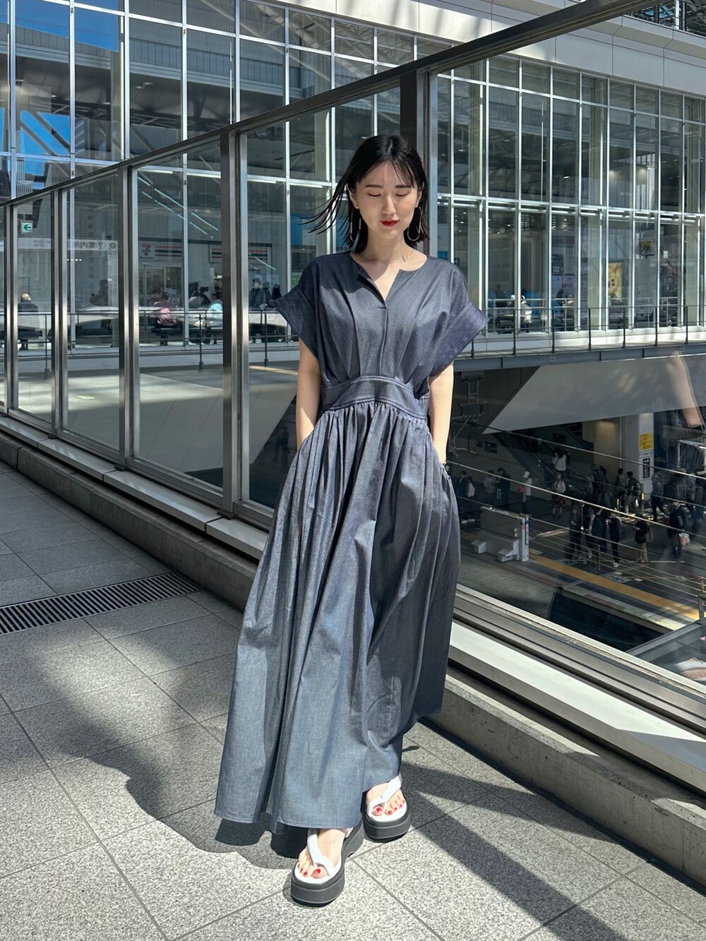 ホワイト系のサンダル、ブルー系のワンピースを着用したレディースの春コーディネートの2枚目の写真