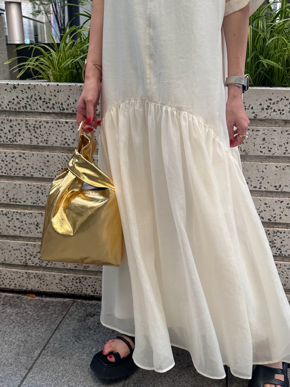 ブラック系のキャミソール、ゴールド系のハンドバッグ、ブラック系のサンダルを着用したレディースの夏コーディネートの6枚目の写真