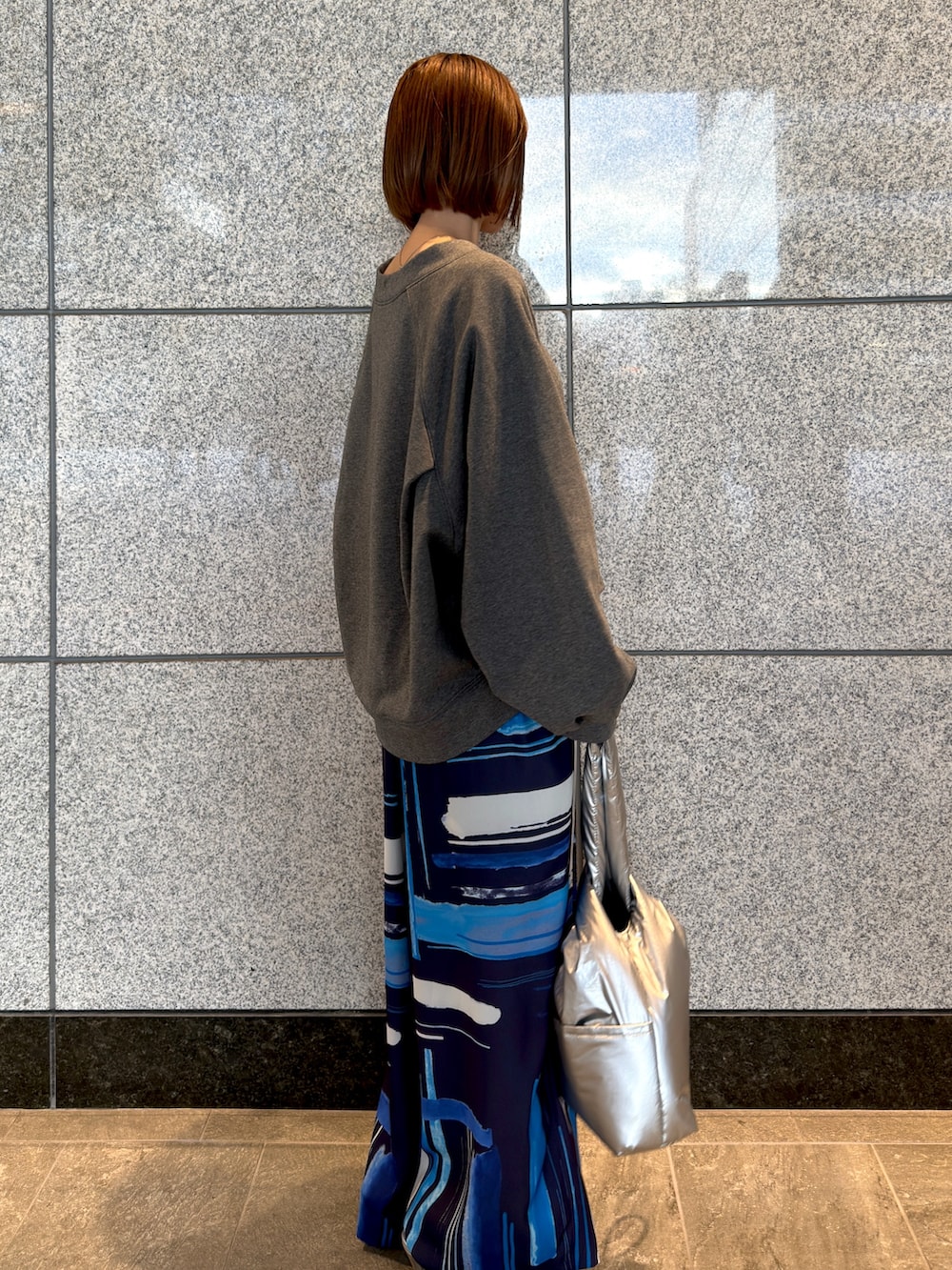 グレー系のTシャツ/カットソー、シルバー系のハンドバッグ、ブルー系のその他パンツを着用したレディースの冬コーディネートの4枚目の写真