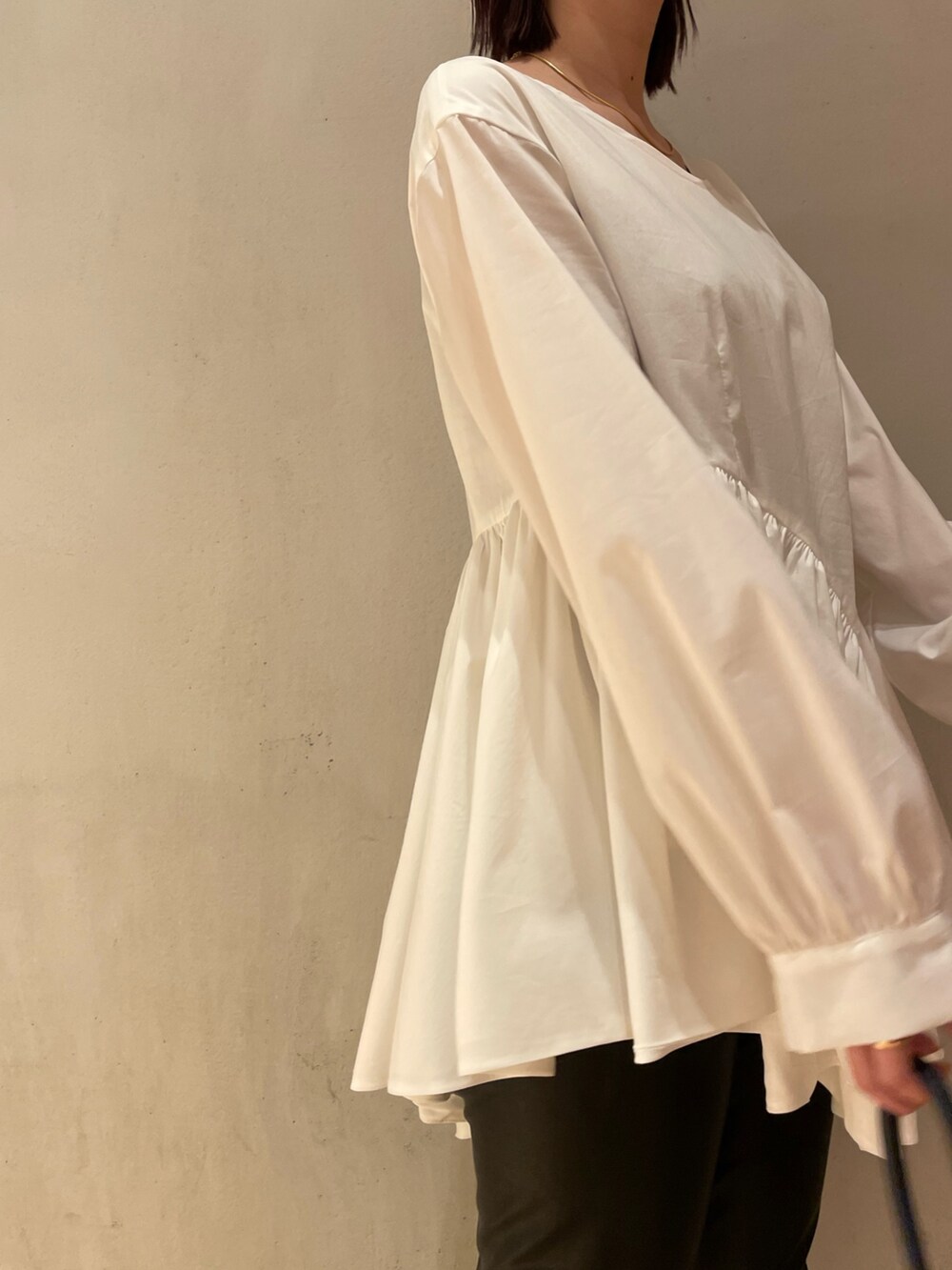 ホワイト系のシャツ/ブラウス、ブラック系のその他パンツ、ベージュ系のハンドバッグを着用したレディースの秋コーディネートの3枚目の写真