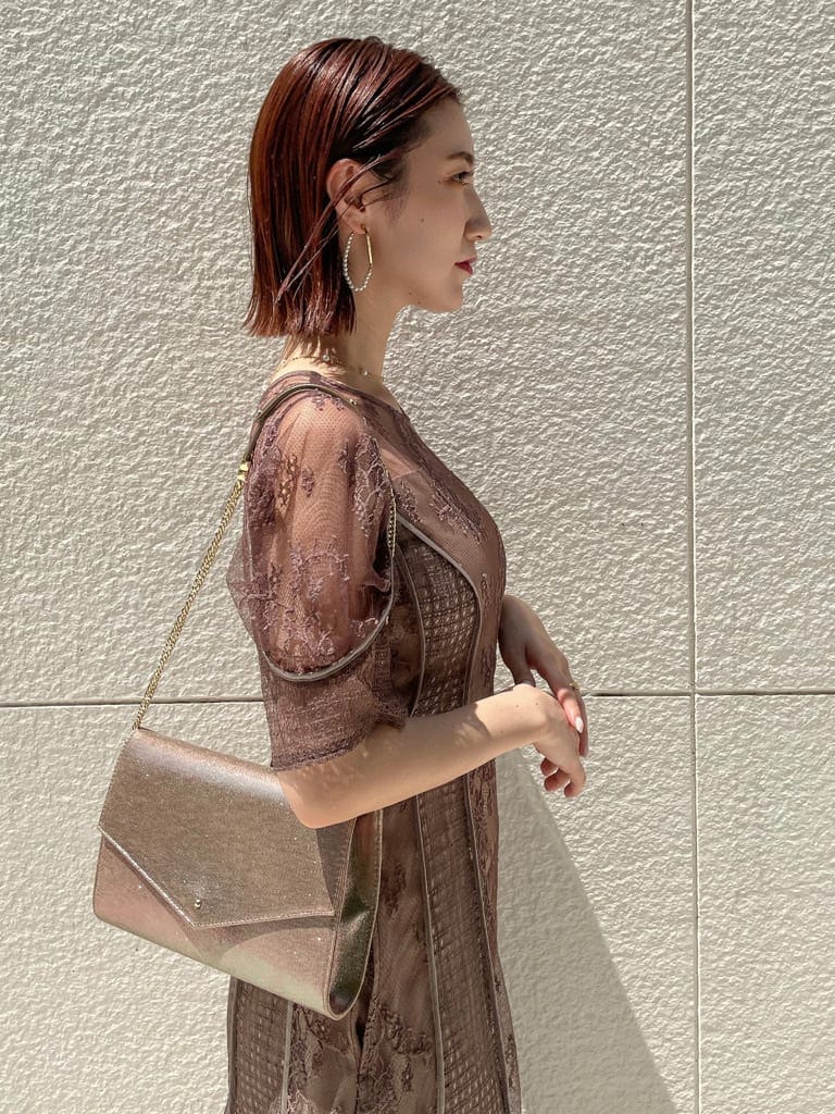 ベージュ系のパンプス、ゴールド系のクラッチバッグ、ベージュ系のドレスを着用したレディースの夏コーディネートの4枚目の写真