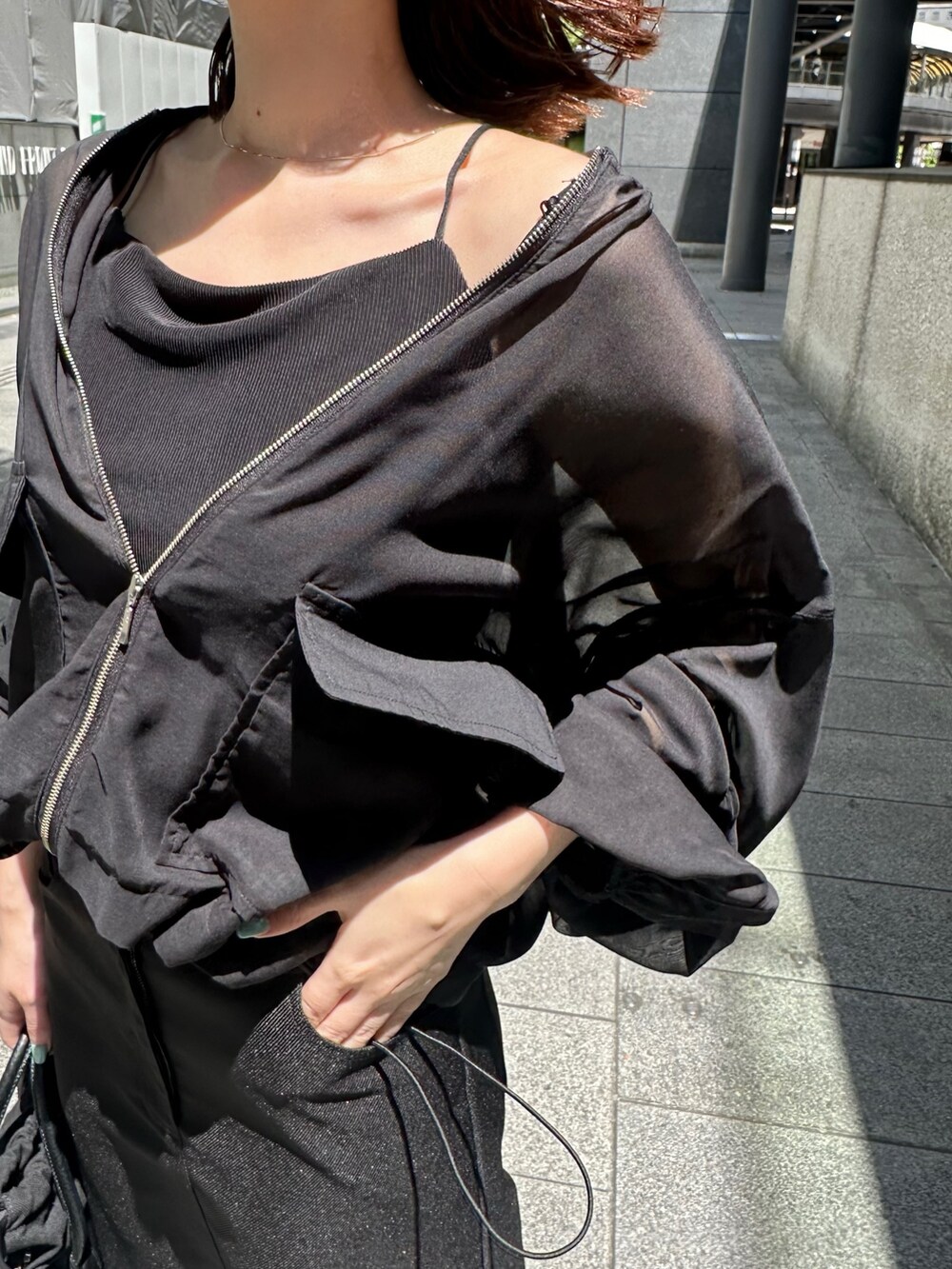 ブラック系のキャミソール、ブラック系のノーカラージャケット、シルバー系のパンプスを着用したレディースの春コーディネートの7枚目の写真