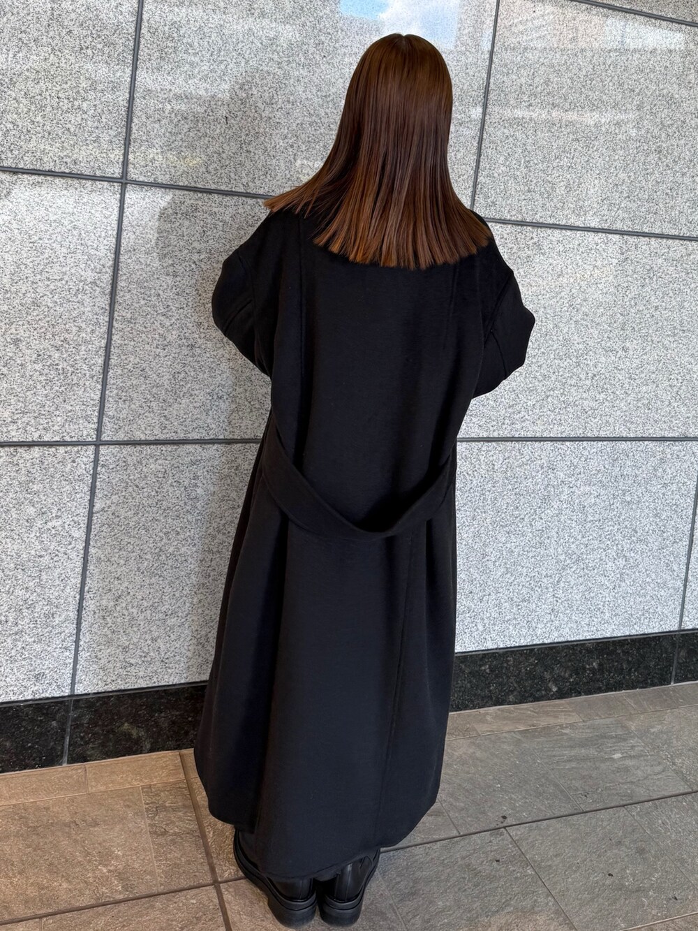 ブラック系のその他アウター、シルバー系のボストンバッグ、ブラック系のブーツを着用したレディースの冬コーディネートの4枚目の写真