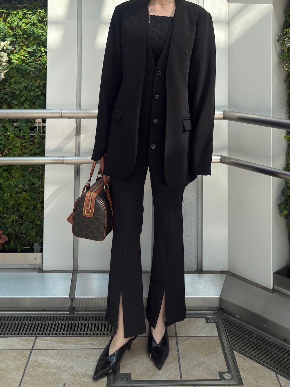 ブラック系のノーカラージャケット、ブラック系のその他パンツ、ブラック系のパンプスを着用したレディースの冬コーディネートの7枚目の写真