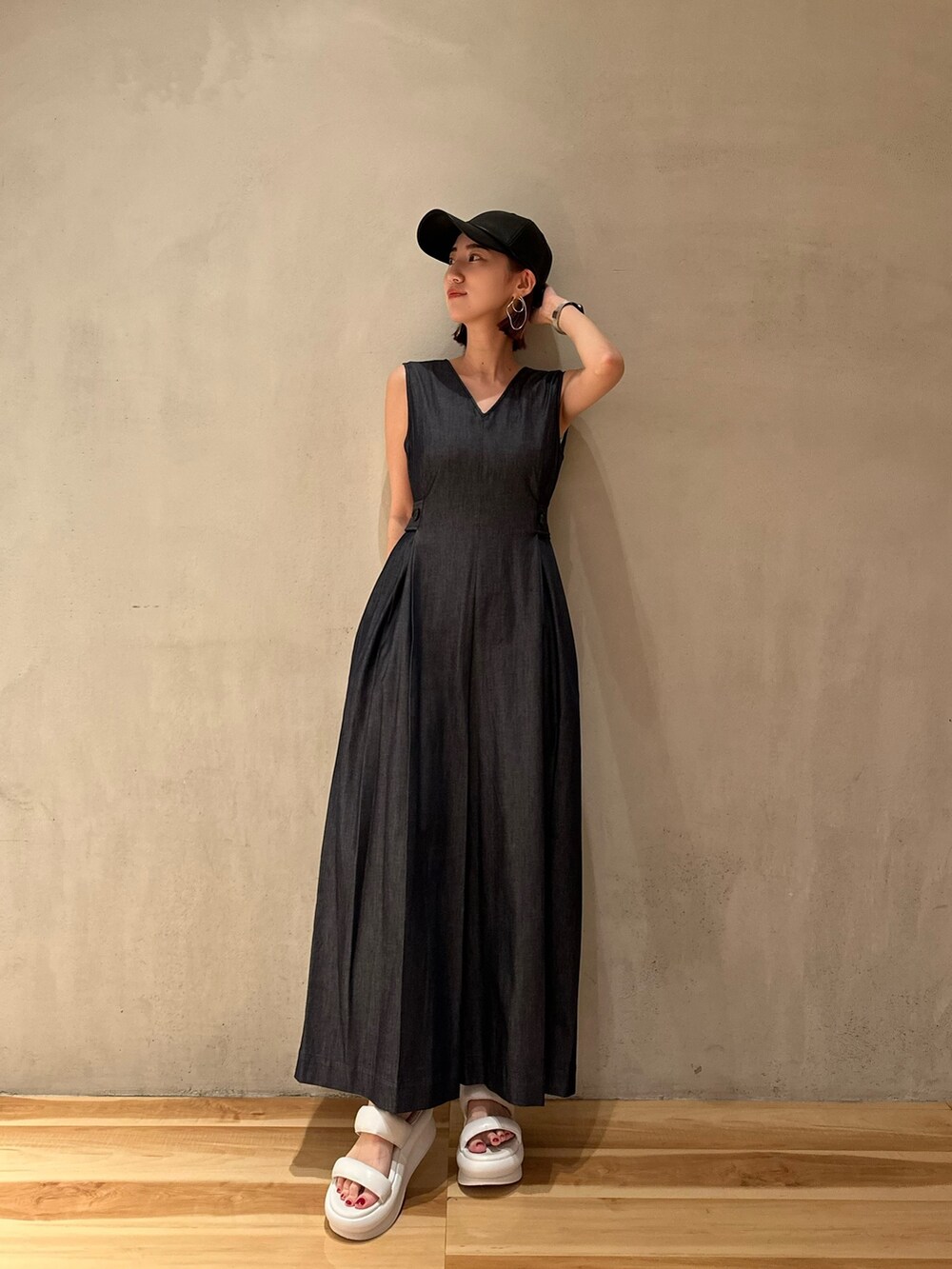 ブルー系のつなぎ/オールインワン、ホワイト系のサンダル、ブラック系のキャップを着用したレディースの夏コーディネートの3枚目の写真