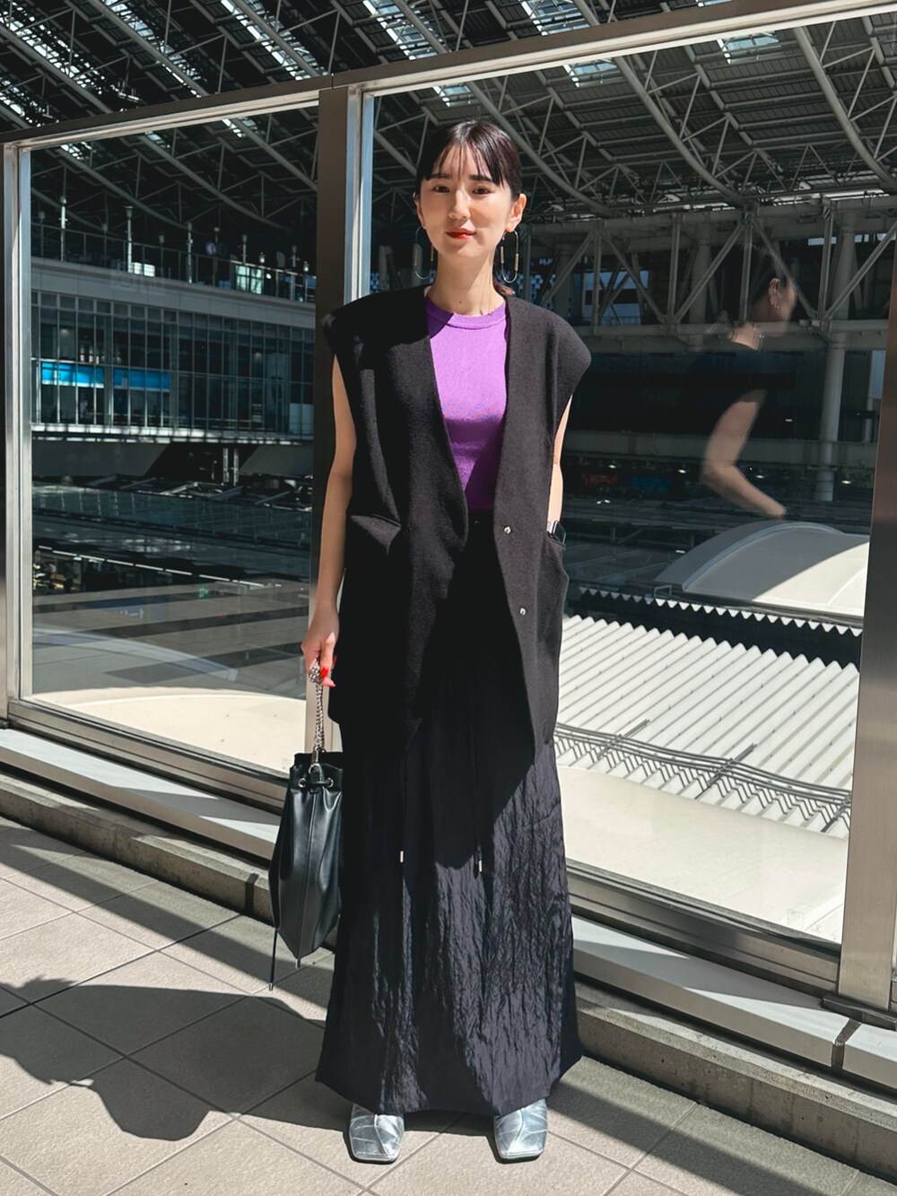 ブラック系のテーラードジャケット、ブルー系のスカート、シルバー系のパンプスを着用したレディースの春コーディネートの3枚目の写真