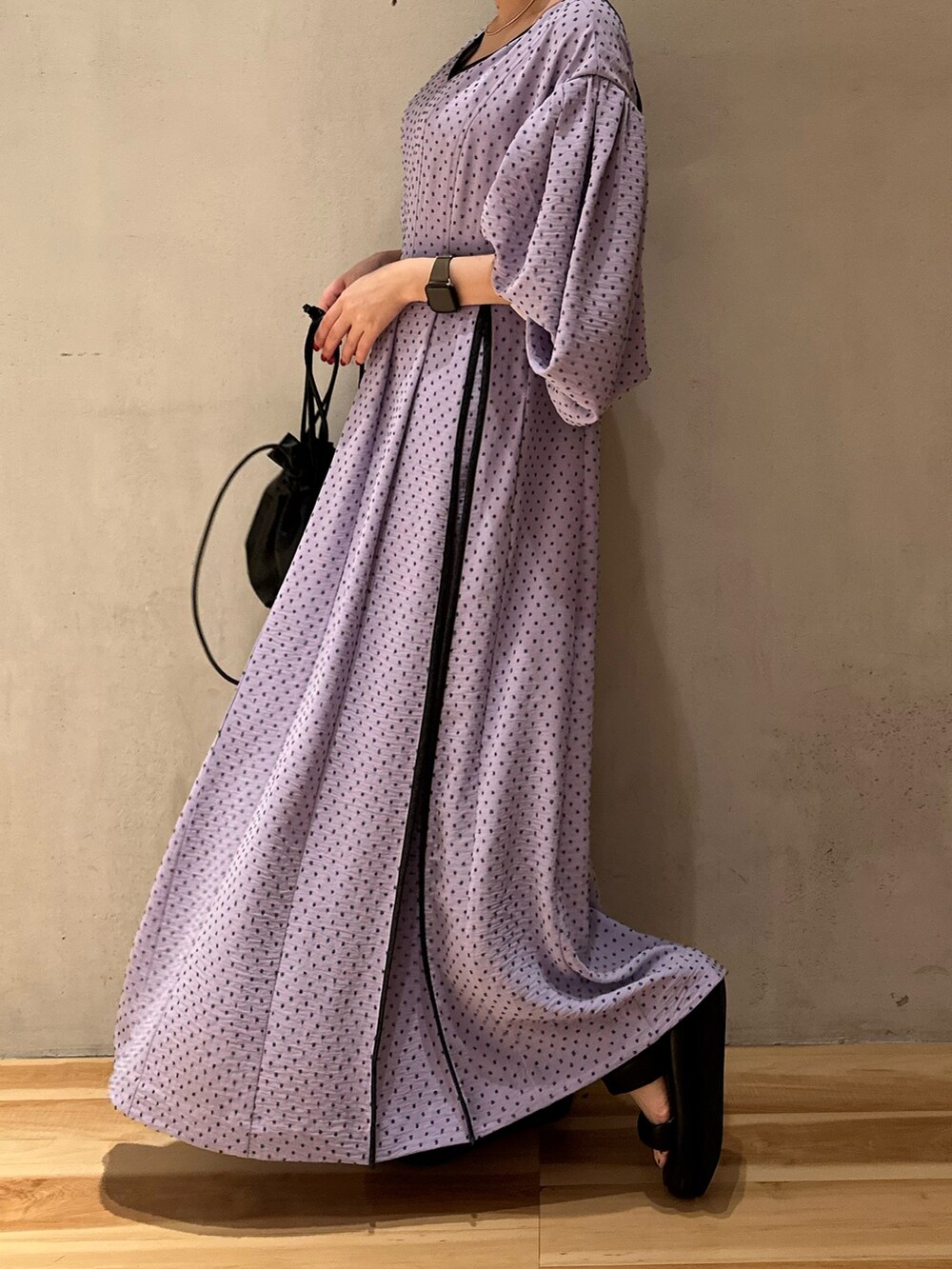 パープル系のワンピース、ベージュ系のテーラードジャケット、ブラック系のサンダルを着用したレディースの冬コーディネートの6枚目の写真