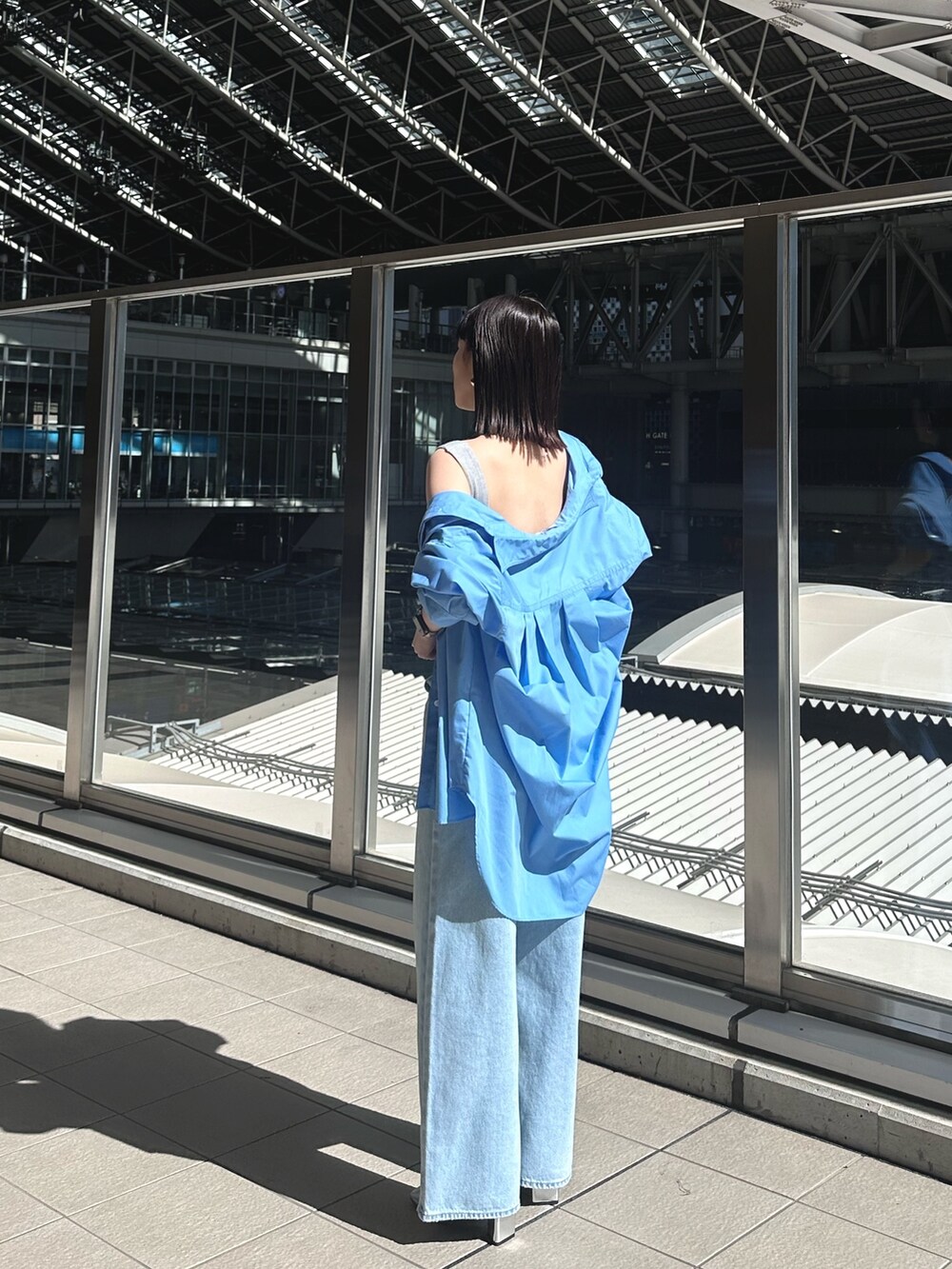 ブルー系のデニムパンツ、シルバー系のパンプス、グレー系のタンクトップを着用したレディースの春コーディネートの9枚目の写真