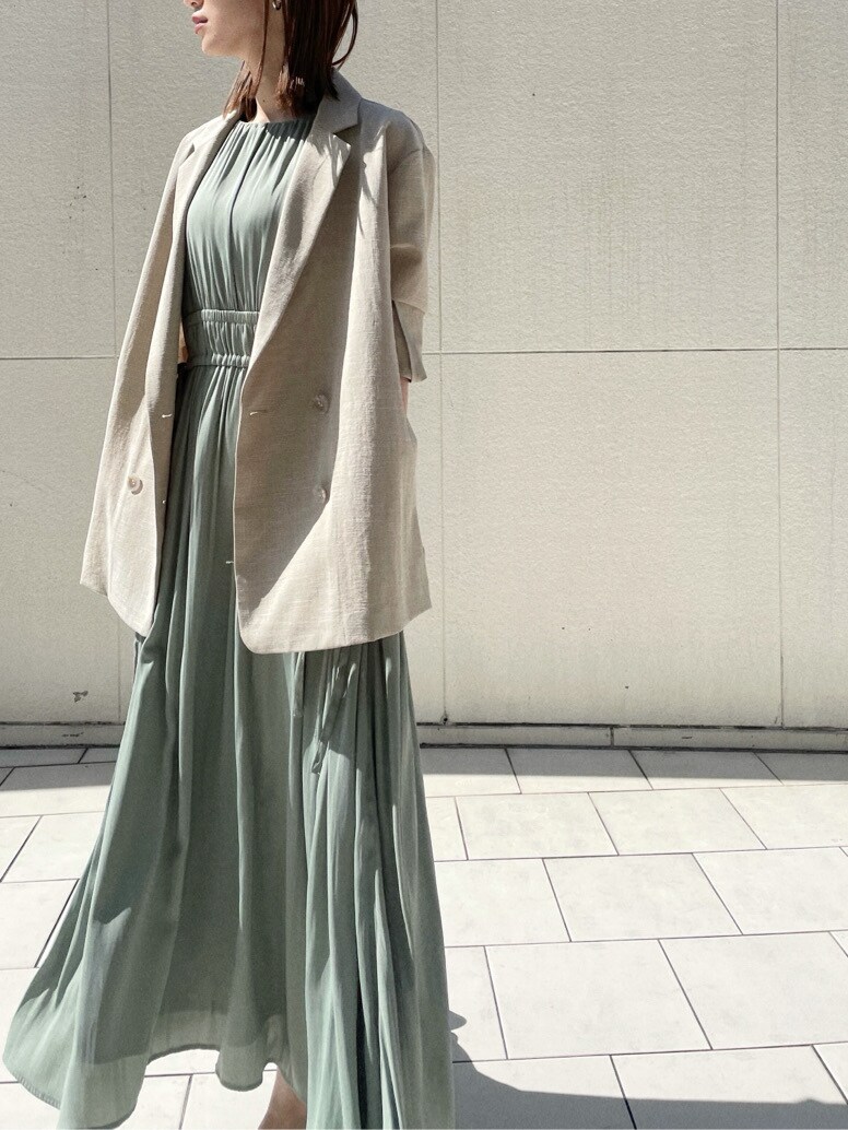 ブラック系のサンダル、ベージュ系のテーラードジャケット、グリーン系のワンピースを着用したレディースの春コーディネートの4枚目の写真