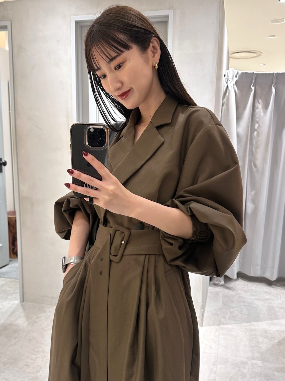 ブラウン系のワンピース、ゴールド系のブーツ、ブラック系のハンドバッグを着用したレディースの秋コーディネートの9枚目の写真