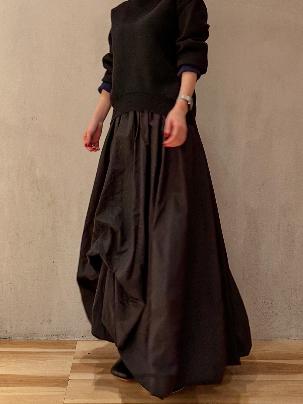 ブラック系のスカート、ブラック系のニット/セーター、ブラック系のブーツを着用したレディースの夏コーディネートの4枚目の写真