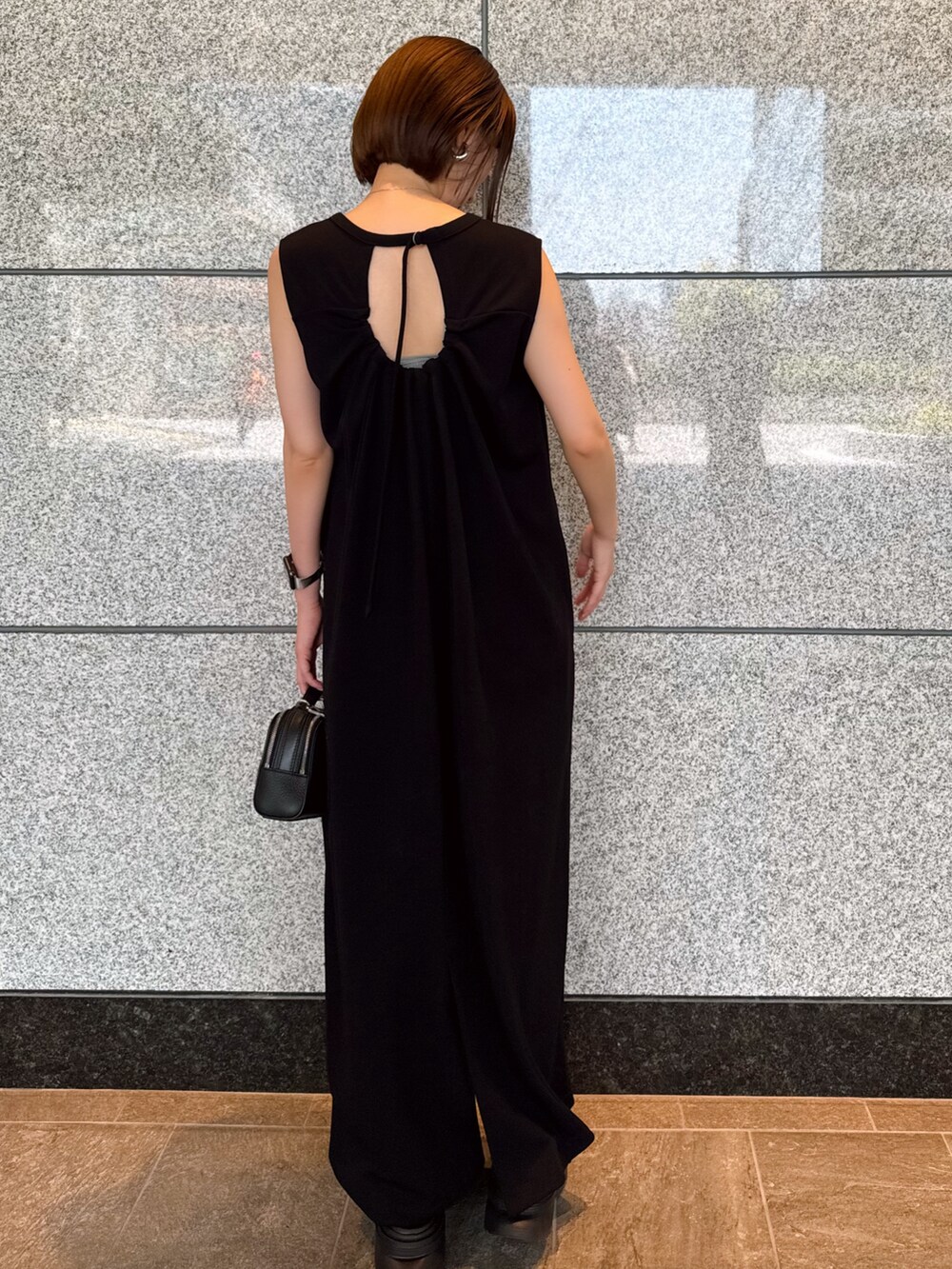 ベージュ系のブルゾン、ブラック系のワンピース、ブラック系のサングラスを着用したレディースの夏コーディネートの4枚目の写真