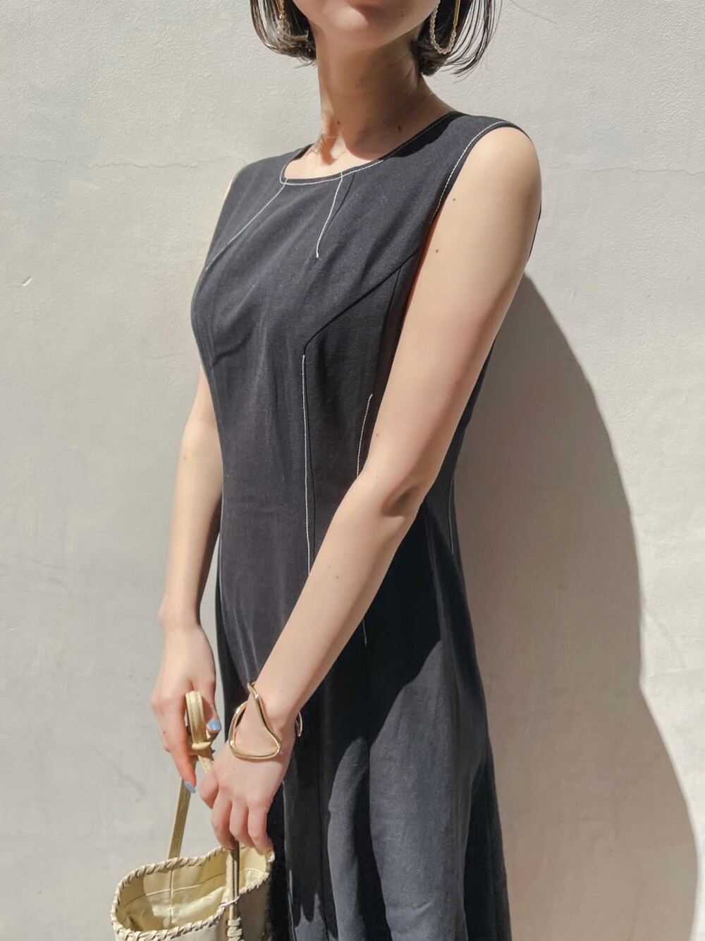 ブラウン系のパンプス、ブラック系のワンピース、ゴールド系のブレスレットを着用したレディースの春コーディネートの5枚目の写真