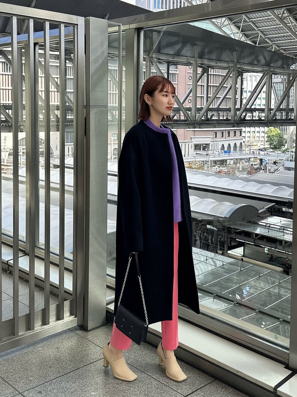 ブラック系のノーカラーコート、ブラック系のショルダーバッグ、ベージュ系のパンプスを着用したレディースの秋コーディネートの2枚目の写真