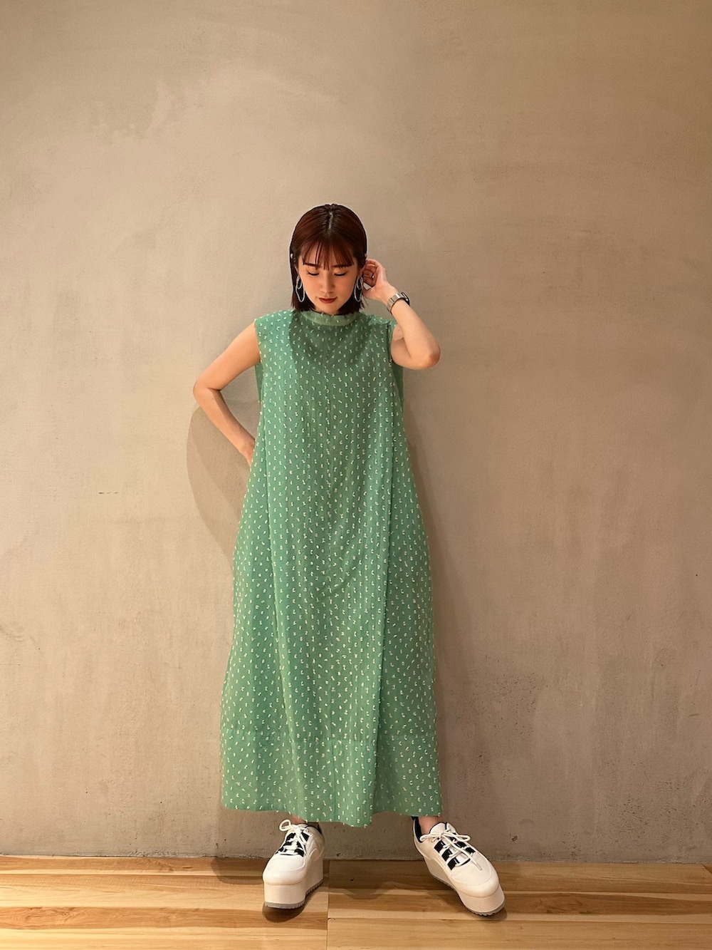 グリーン系のワンピース、ホワイト系のスニーカーを着用したレディースの夏コーディネートの3枚目の写真