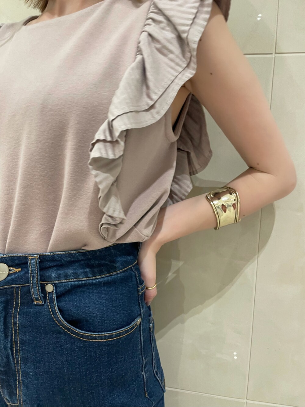 ブルー系のデニムパンツ、ブラック系のハンドバッグ、ブラック系のサンダルを着用したレディースの春コーディネートの3枚目の写真