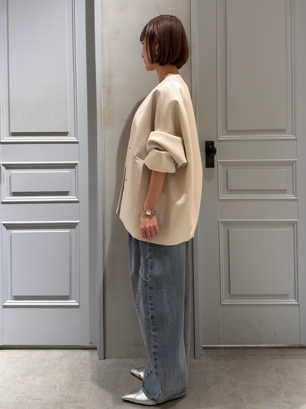 ベージュ系のその他アウター、ブルー系のデニムパンツ、シルバー系のパンプスを着用したレディースの春コーディネートの3枚目の写真