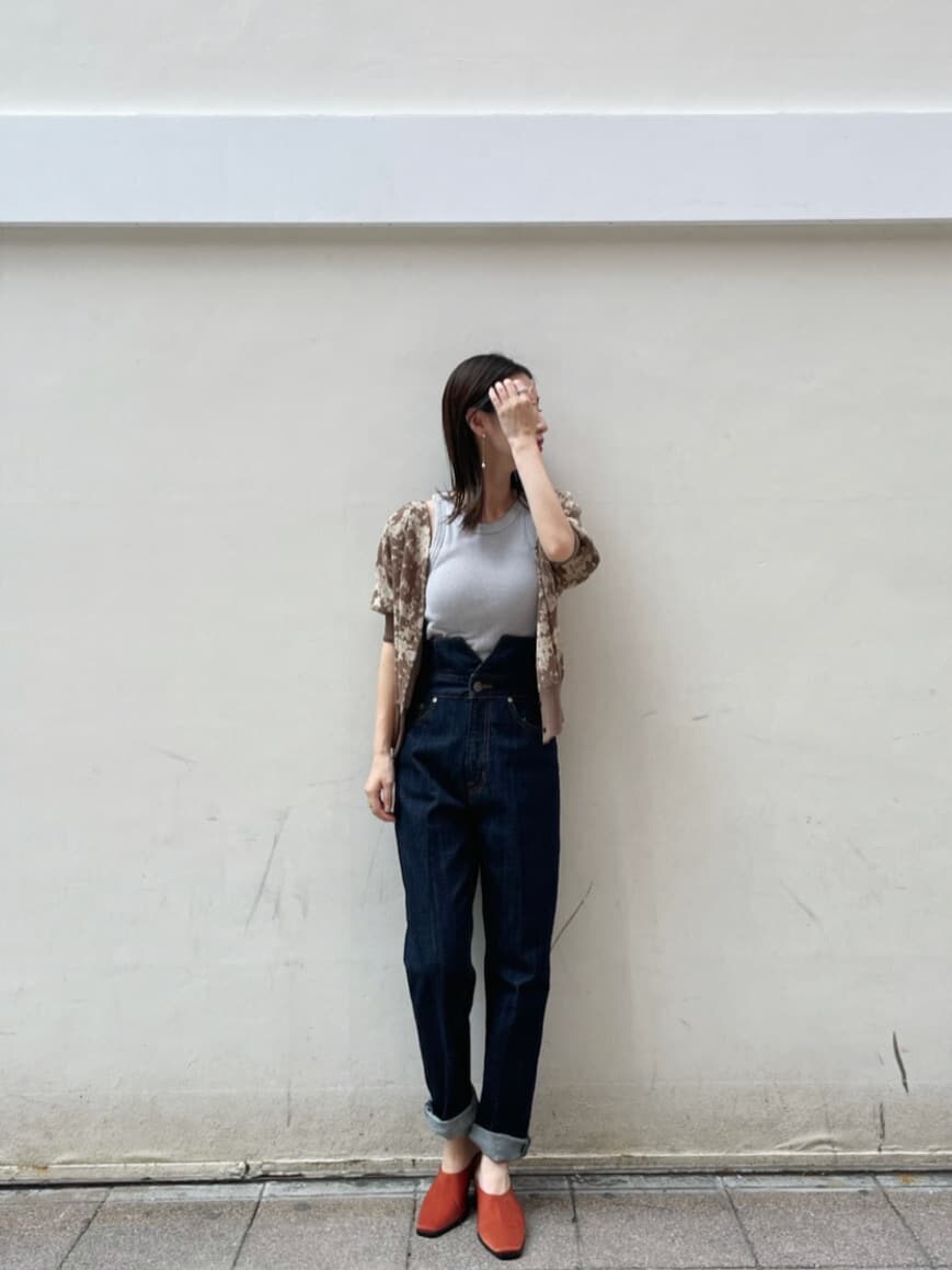 ブルー系のデニムパンツ、オレンジ系のスリッポン、ブラウン系のニット/セーターを着用したレディースの秋コーディネートの6枚目の写真