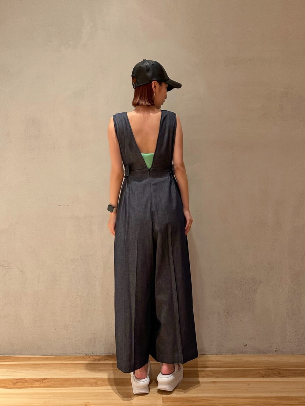 ブルー系のつなぎ/オールインワン、ホワイト系のサンダル、ブラック系のキャップを着用したレディースの夏コーディネートの2枚目の写真