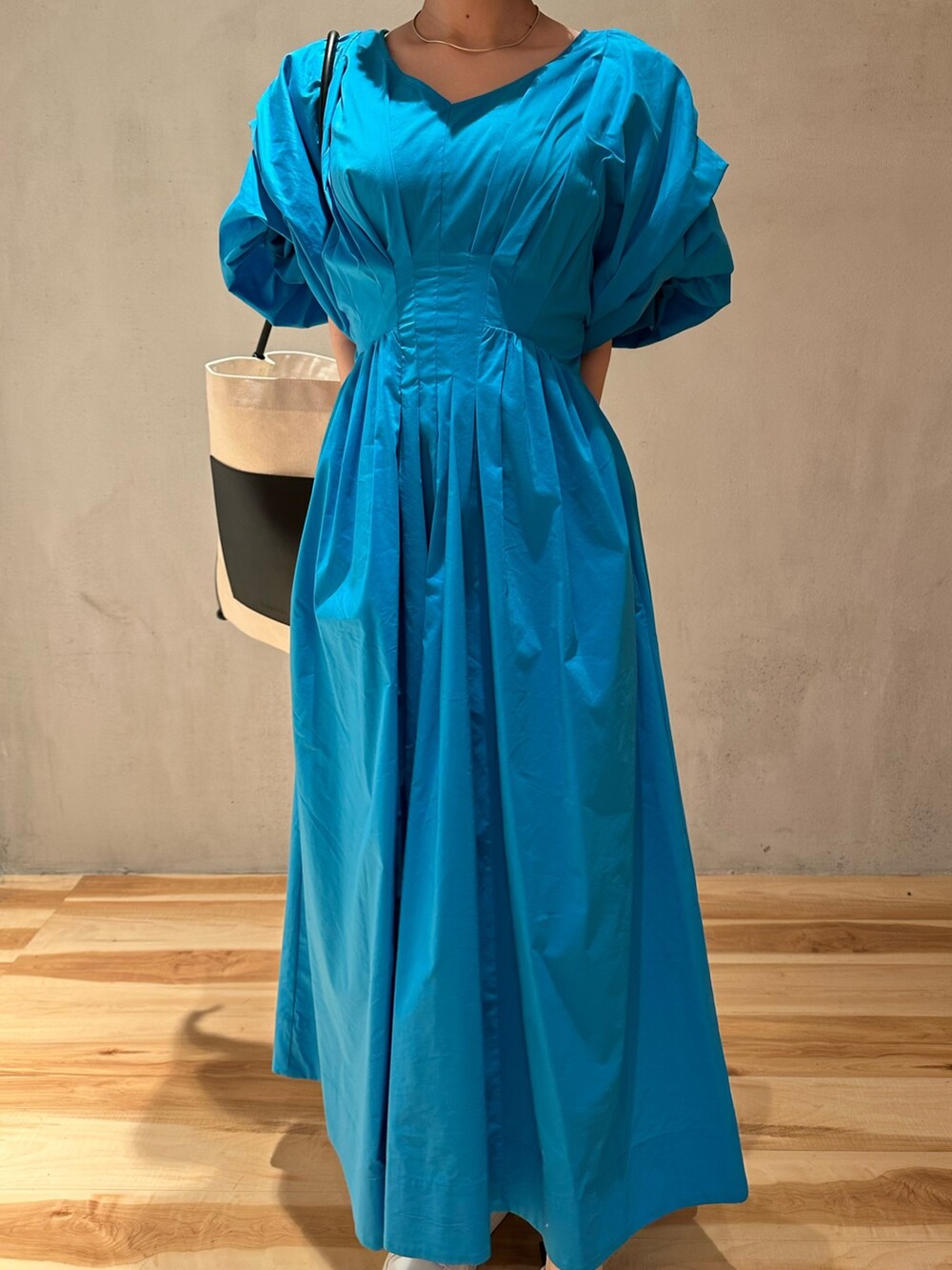 その他のトートバッグ、ブルー系のワンピース、ホワイト系のスニーカーを着用したレディースの春コーディネートの3枚目の写真