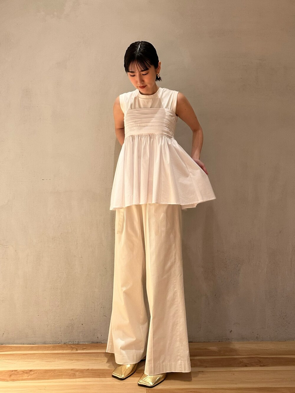ホワイト系のタンクトップ、ホワイト系のその他パンツ、ゴールド系のパンプスを着用したレディースの春コーディネートの2枚目の写真