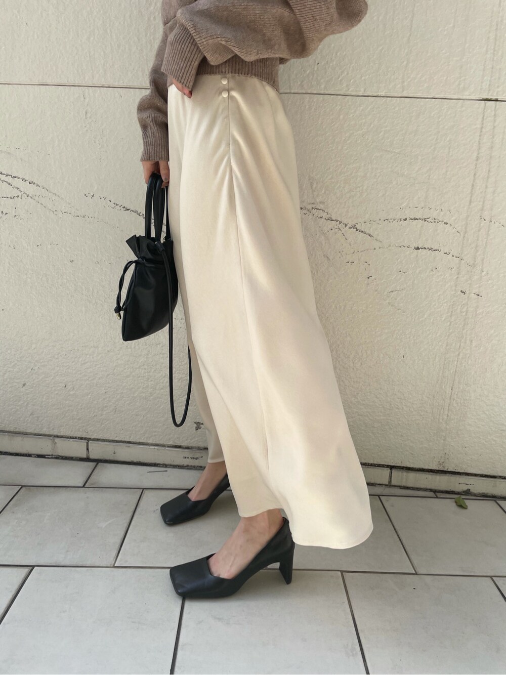 ホワイト系のスカート、ベージュ系のニット/セーターを着用したレディースの冬コーディネートの5枚目の写真