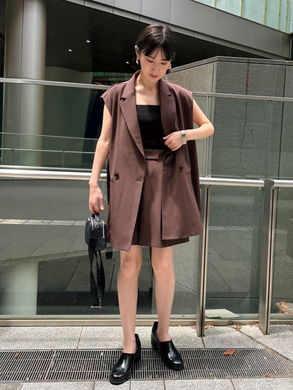 ブラウン系のテーラードジャケット、ブラウン系のその他パンツ、ブラック系のパンプスを着用したレディースの夏コーディネートの2枚目の写真