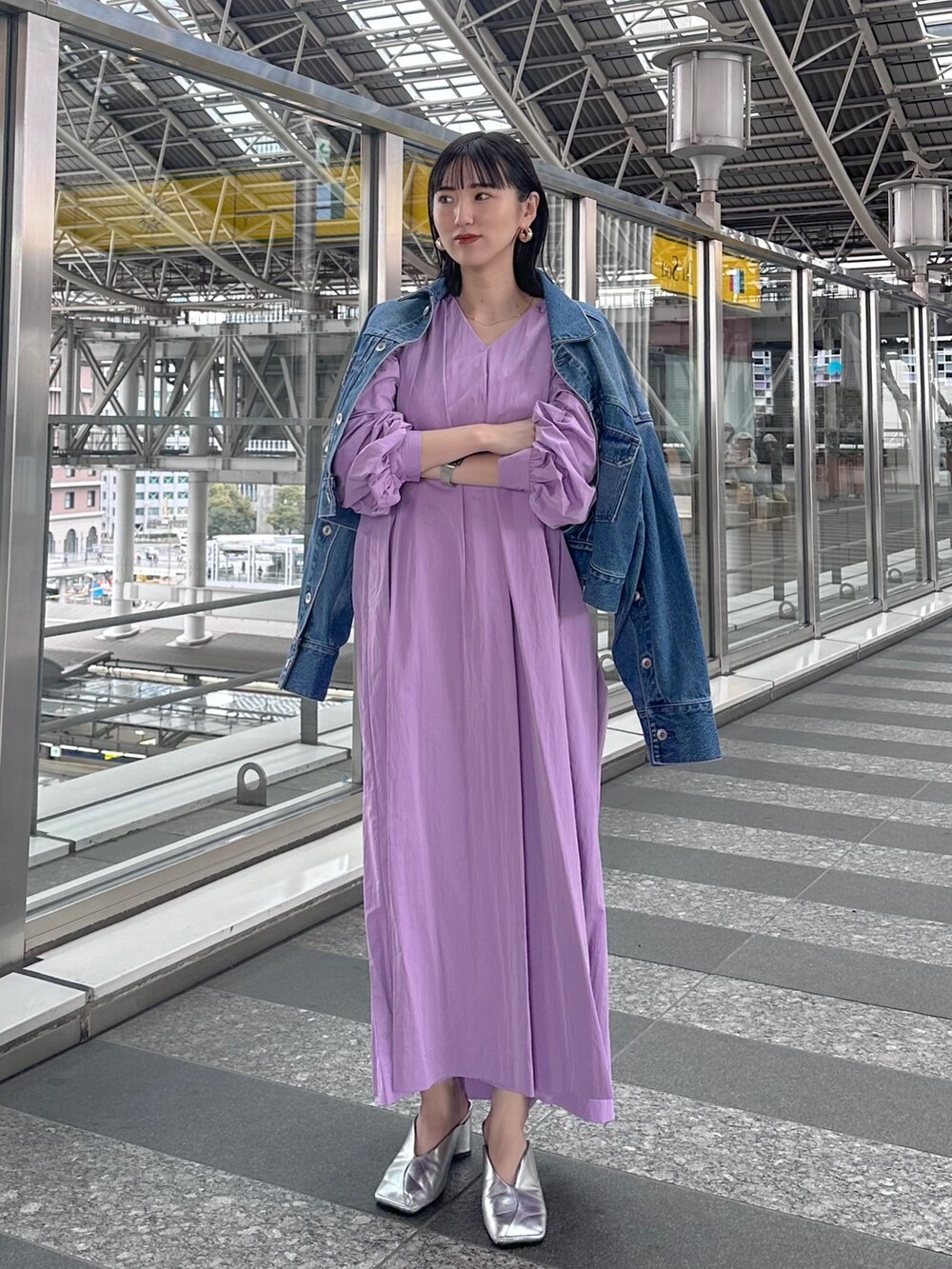 パープル系のワンピース、ブルー系のデニムジャケット、シルバー系のパンプスを着用したレディースの春コーディネートの3枚目の写真