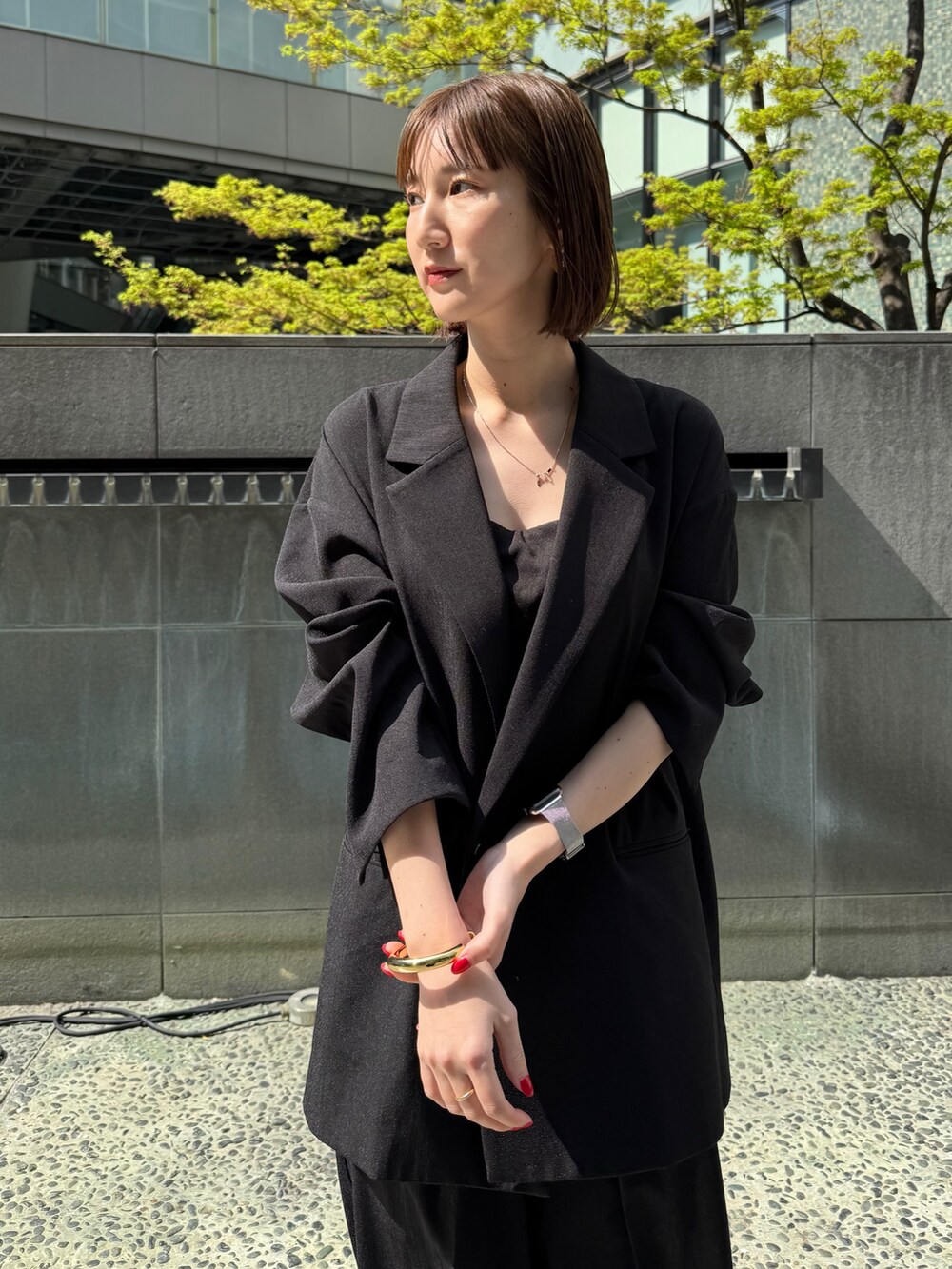 ブラック系のテーラードジャケット、ブラック系のその他パンツ、ゴールド系のサンダルを着用したレディースの春コーディネートの2枚目の写真