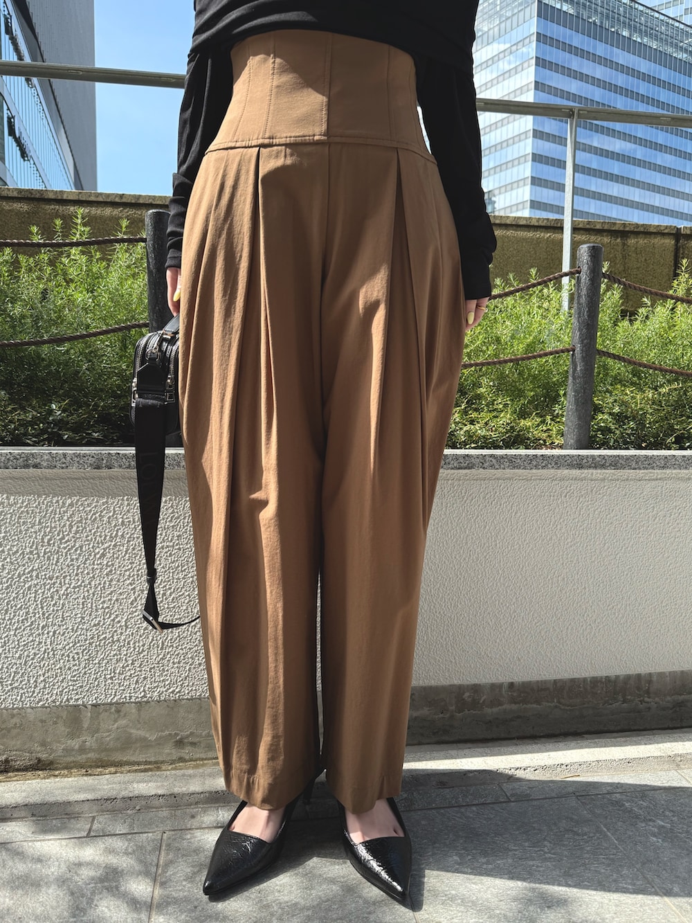 ブラック系のTシャツ/カットソー、ブラック系のサンダル、ブラウン系のその他パンツを着用したレディースの春コーディネートの8枚目の写真