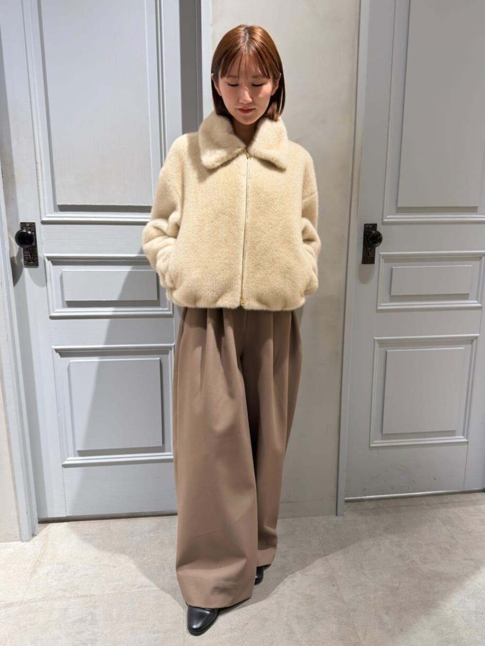 ベージュ系のブルゾン、ブラウン系のその他パンツを着用したレディースの冬コーディネートの2枚目の写真