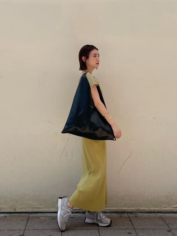 イエロー系のワンピース、ゴールド系のブレスレットを着用したレディースの夏コーディネートの8枚目の写真