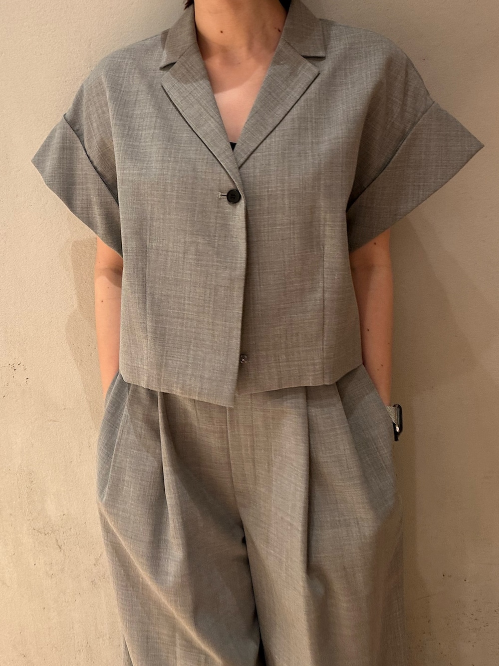 グレー系のテーラードジャケット、ブラック系のショルダーバッグ、ブラック系のバレエシューズを着用したレディースの夏コーディネートの7枚目の写真