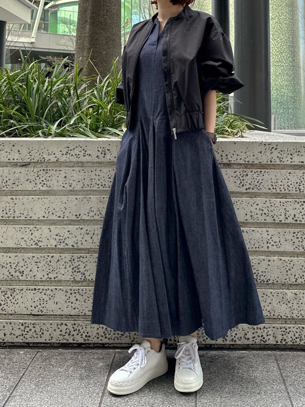 ホワイト系のスニーカー、ブルー系のワンピース、ブラック系のブルゾンを着用したレディースの春コーディネートの5枚目の写真